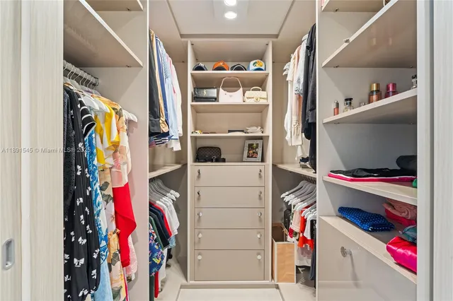 a view of walk in closet with clothes and shoes