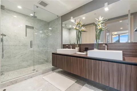 a bathroom with double vanity and a mirror