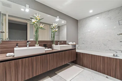 a bathroom with 2 sink tub and a mirror