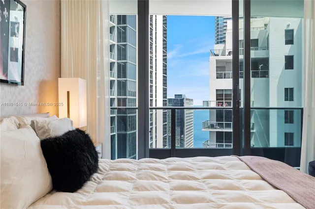 a large bedroom with a bed and wooden floor