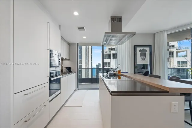 a large kitchen with granite countertop a lot of counter space and stainless steel appliances