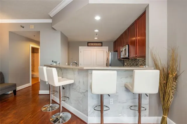 a kitchen with granite countertop a table chairs refrigerator and sink