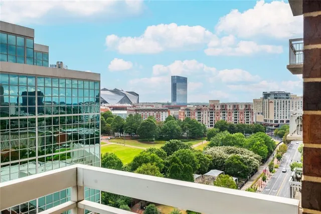 a view of a balcony with a floor to ceiling window next to a tall building