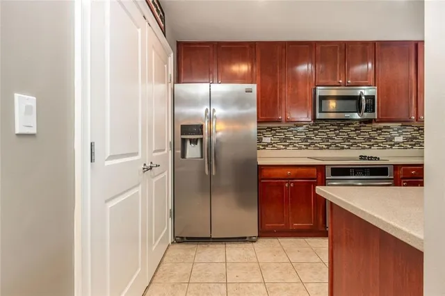 a kitchen with stainless steel appliances granite countertop a refrigerator and a stove