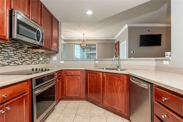 a kitchen with stainless steel appliances granite countertop wooden cabinets a stove top oven a sink and dishwasher