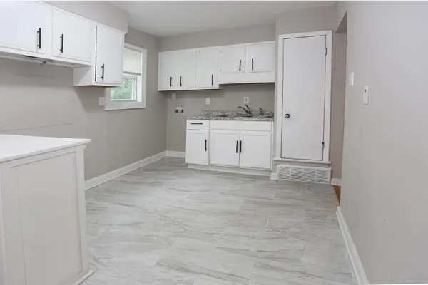 a kitchen with cabinets appliances a sink and a stove