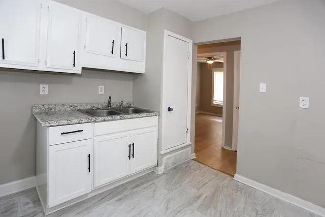 a kitchen with granite countertop white cabinets and stainless steel appliances