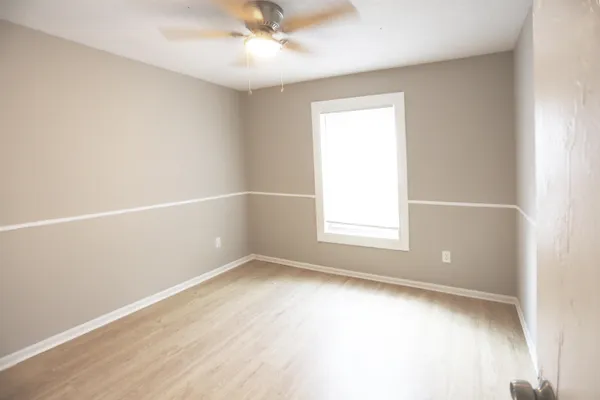 an empty room with a window and wooden floor