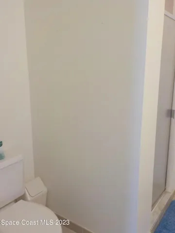 a white toilet sitting next to a shower