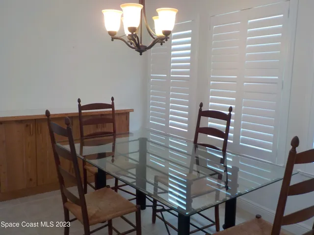 a view of a dining room with furniture and a chandelier