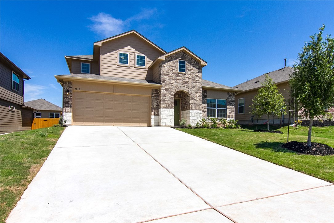 a front view of a house with a yard and garage
