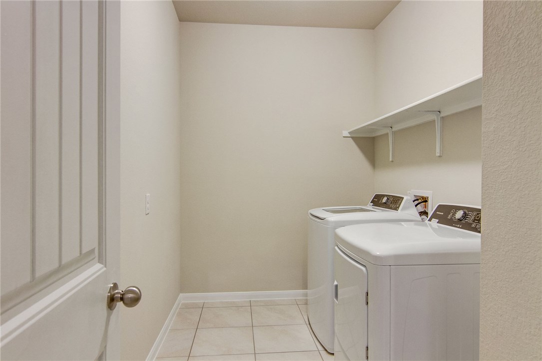7012 Ranchito Drive Austin, TX 78744 - Photo 28 of 34 a bathroom with a sink a washer and dryer