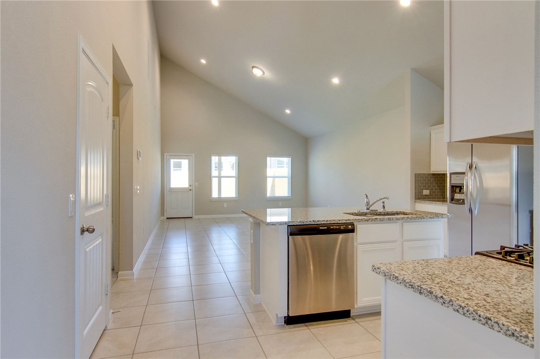 7012 Ranchito Drive Austin, TX 78744 - Photo 7 of 34 a kitchen with a sink stove and refrigerator