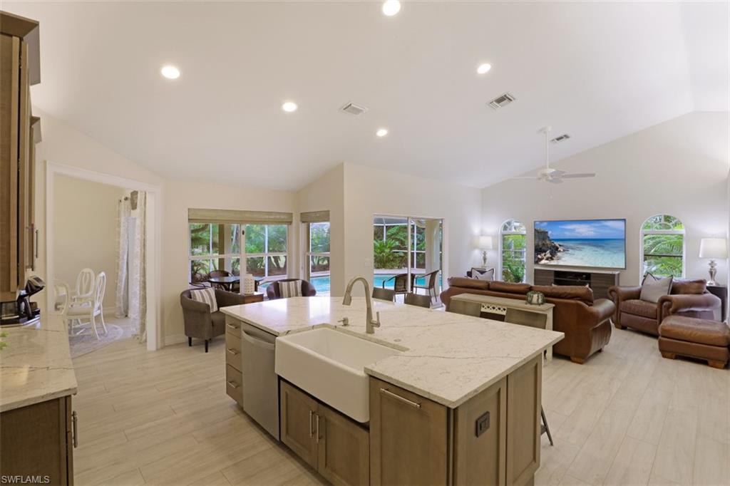 471 Ibis Way Naples, FL 34110 - Photo 12 of 32 a large living room with stainless steel appliances furniture a flat screen tv and a large window