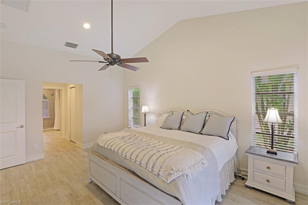 471 Ibis Way Naples, FL 34110 - Photo 19 of 32 a bedroom with a balcony a bed and a chandelier