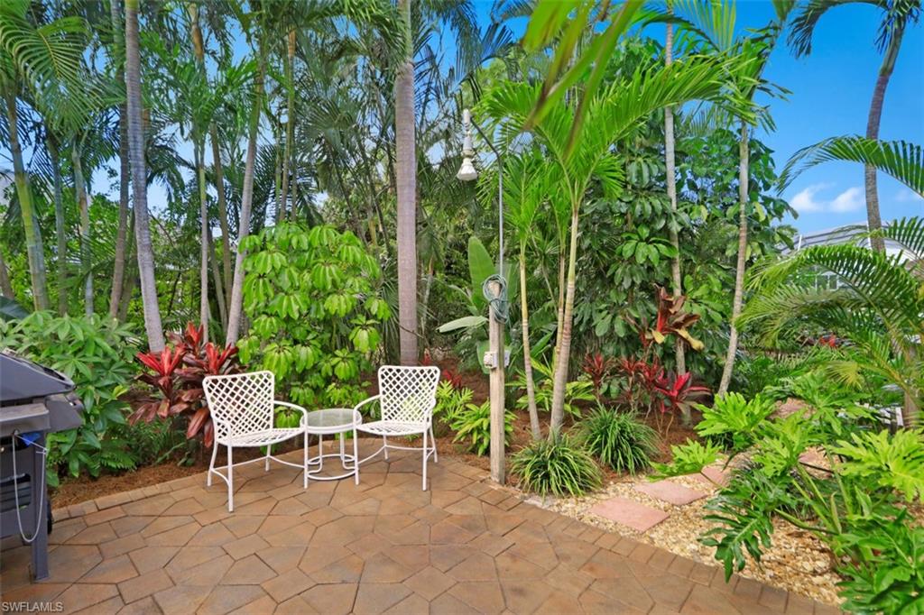 471 Ibis Way Naples, FL 34110 - Photo 27 of 32 a chair and a table in a garden