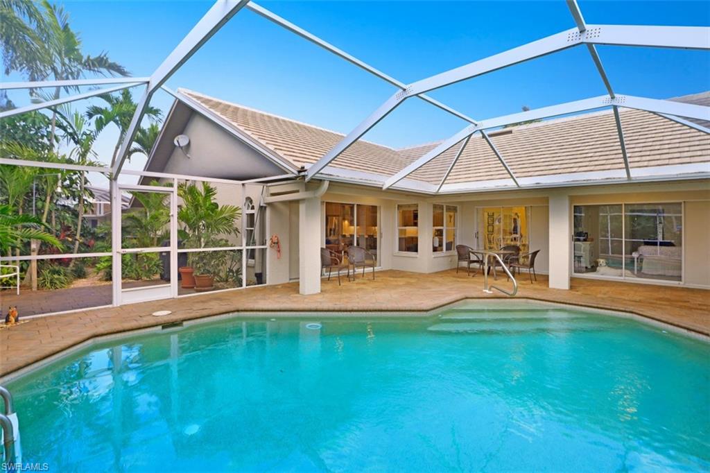 471 Ibis Way Naples, FL 34110 - Photo 4 of 32 a view of pool with a table and chairs under an umbrella