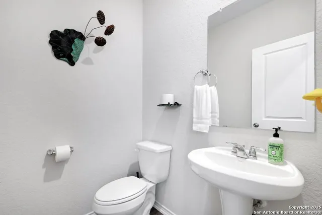 a bathroom with a sink toilet and mirror