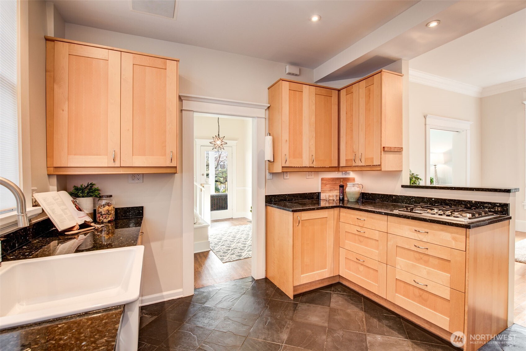 1523 35th Avenue Seattle, WA 98122 - Photo 14 of 35 a kitchen with stainless steel appliances granite countertop a stove a sink and white cabinets with wooden floor