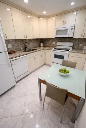 a kitchen with stainless steel appliances granite countertop a sink a stove a microwave a counter top and cabinets