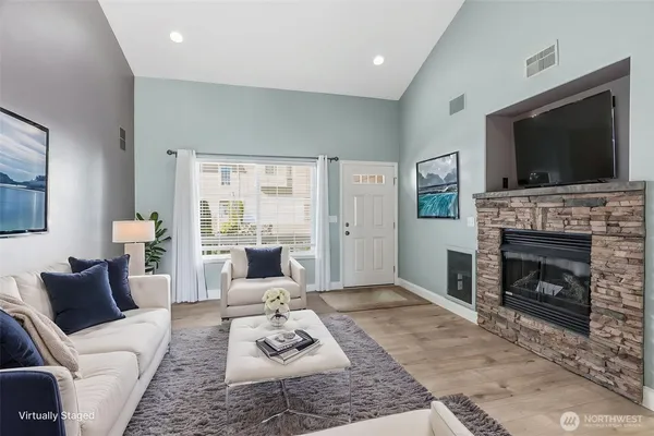a living room with furniture a flat screen tv and a fireplace