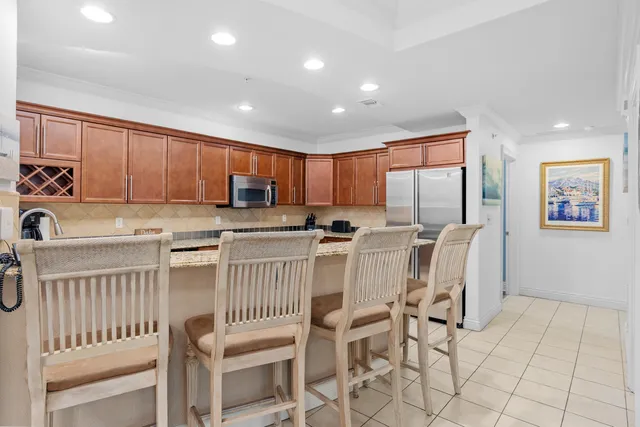 a kitchen with stainless steel appliances granite countertop a stove top oven a sink a table and chairs