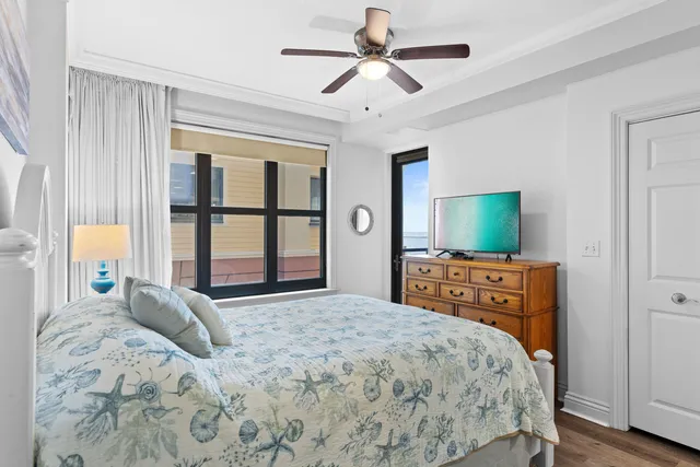 a bedroom with a large bed and a flat tv screen on dresser