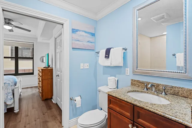 a bathroom with a granite countertop toilet sink and mirror