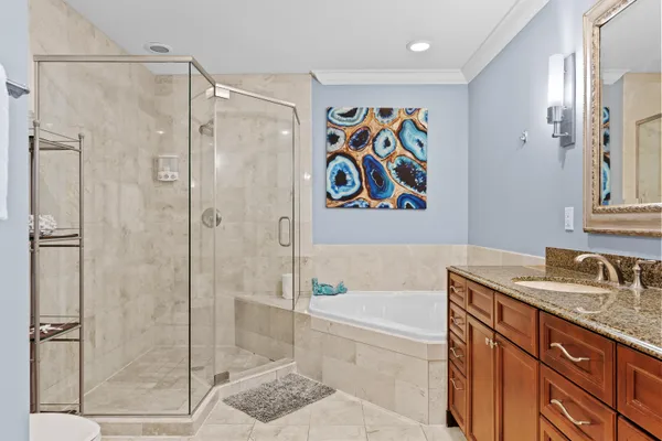 a bathroom with a granite countertop sink a mirror a bathtub and shower