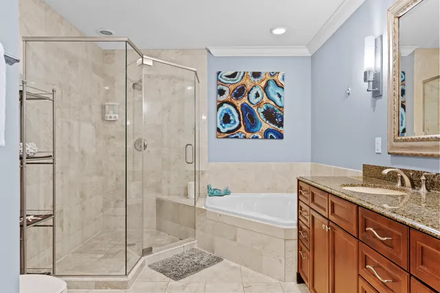 a bathroom with a granite countertop sink a mirror a bathtub and shower