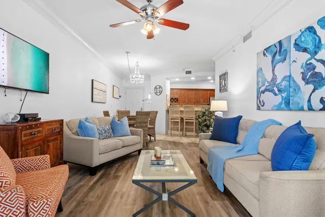 a living room with furniture kitchen view and a flat screen tv