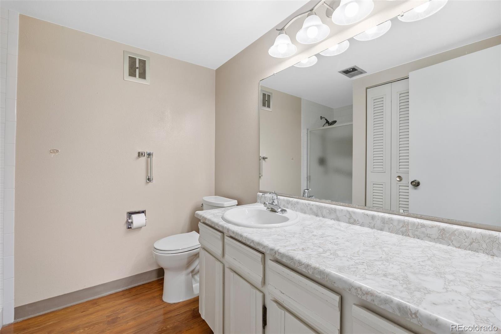 6495 East Happy Canyon Road, Unit 171 Denver, CO 80237 - Photo 23 of 27 a bathroom with a granite countertop sink a toilet and a mirror