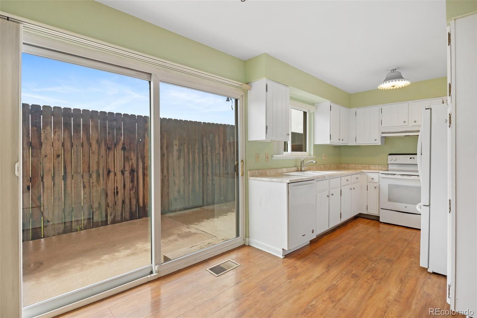 6495 East Happy Canyon Road, Unit 171 Denver, CO 80237 - Photo 8 of 27 a kitchen with a refrigerator a sink and white cabinets