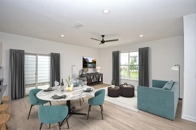 a living room with furniture kitchen view and a large window