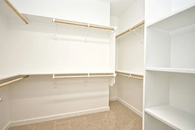 a view of walk in closet with empty racks