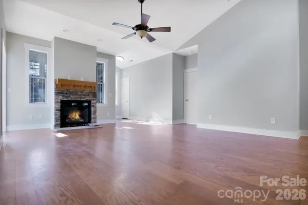 a view of empty room with wooden floor and fireplace