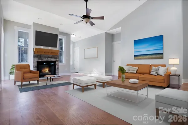 a living room with furniture a flat screen tv and a fireplace