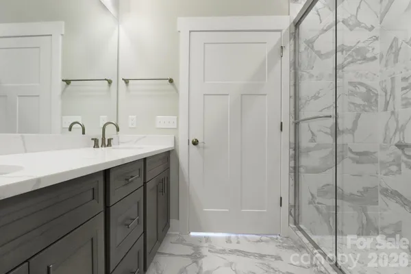 a bathroom with a shower sink and mirror