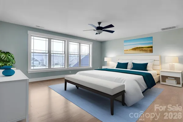 a spacious bedroom with a large bed and a chandelier