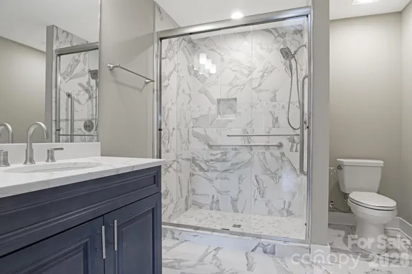 a bathroom with a granite countertop sink toilet and shower