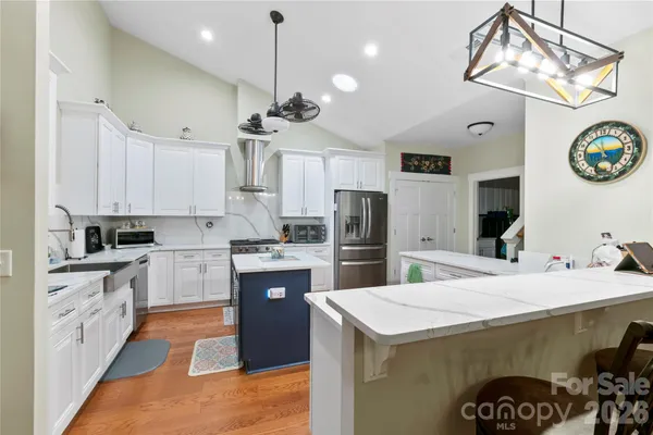 a kitchen with a refrigerator a stove top oven a clock and a window