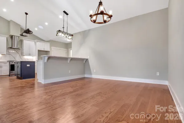 a view of a room with wooden floor and ceiling fan