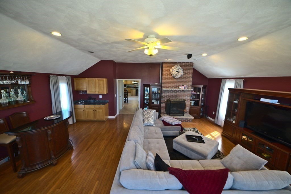 8 Sparrow Road Stoughton, MA 02072 - Photo 15 of 28 a living room with furniture a flat screen tv and a fireplace