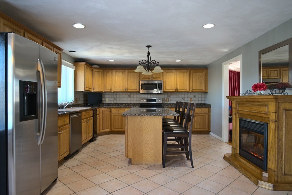 8 Sparrow Road Stoughton, MA 02072 - Photo 9 of 28 a kitchen with kitchen island granite countertop cabinets and steel stainless steel appliances