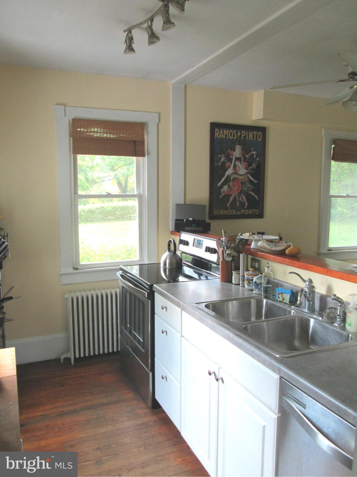 3061 Evans Road Riva, MD 21140 - Photo 4 of 22 a kitchen with stainless steel appliances granite countertop a sink dishwasher a stove and white cabinets with wooden floor