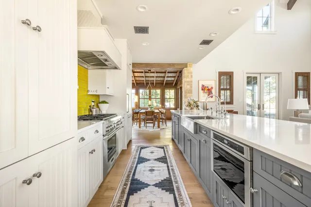 a large kitchen with stainless steel appliances granite countertop a lot of counter space and wooden floors
