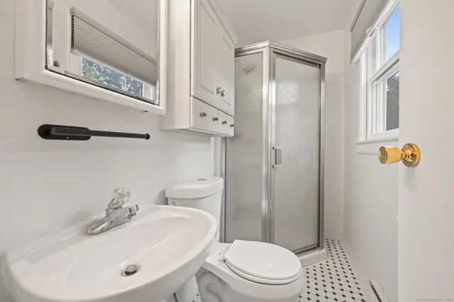 a bathroom with a sink a toilet and shower