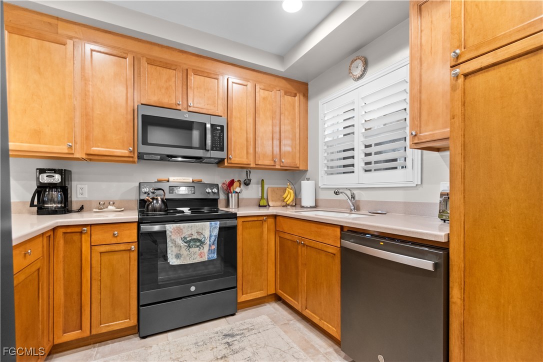 2110 West First Street, Unit 101 Fort Myers, FL 33901 - Photo 12 of 38 a kitchen with stainless steel appliances granite countertop wooden cabinets and a stove top oven