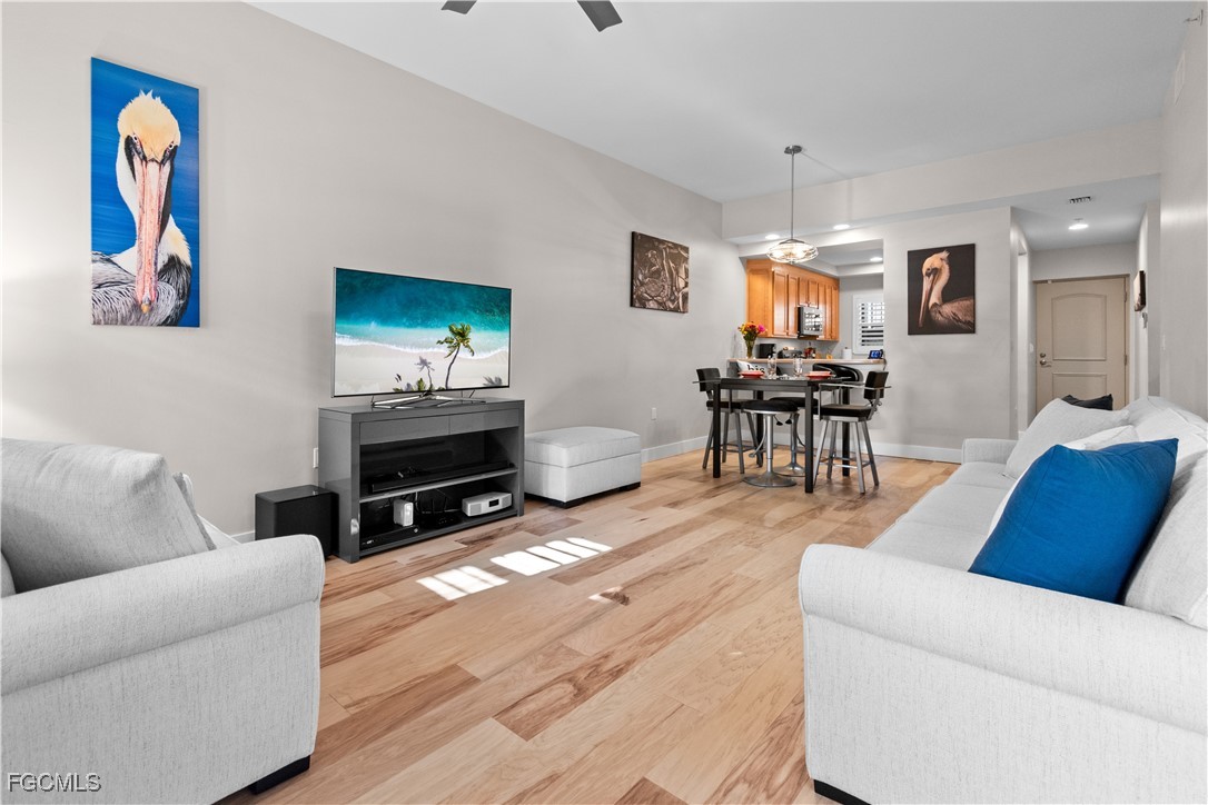 2110 West First Street, Unit 101 Fort Myers, FL 33901 - Photo 3 of 34 a living room with furniture and a flat screen tv with wooden floor