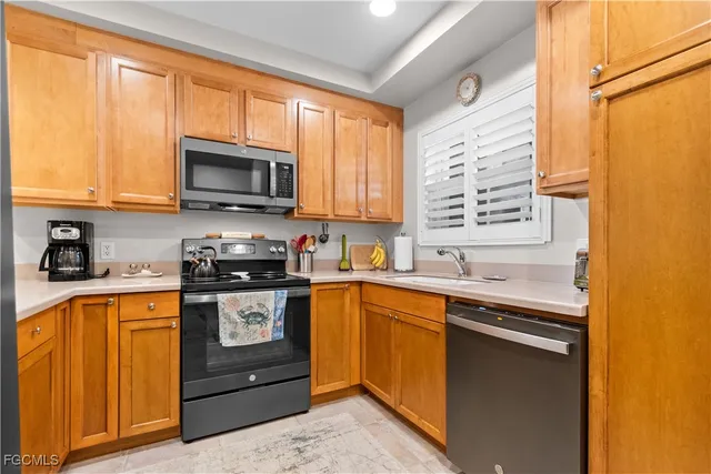 a kitchen with stainless steel appliances granite countertop wooden cabinets and a stove top oven
